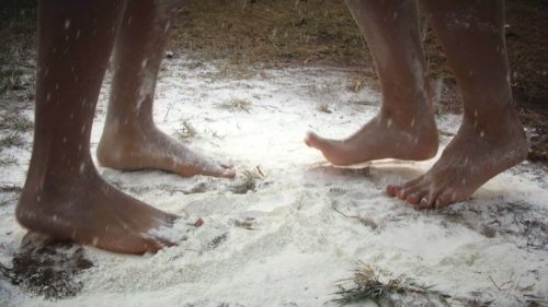 naked feet of two persons on white powdered ground